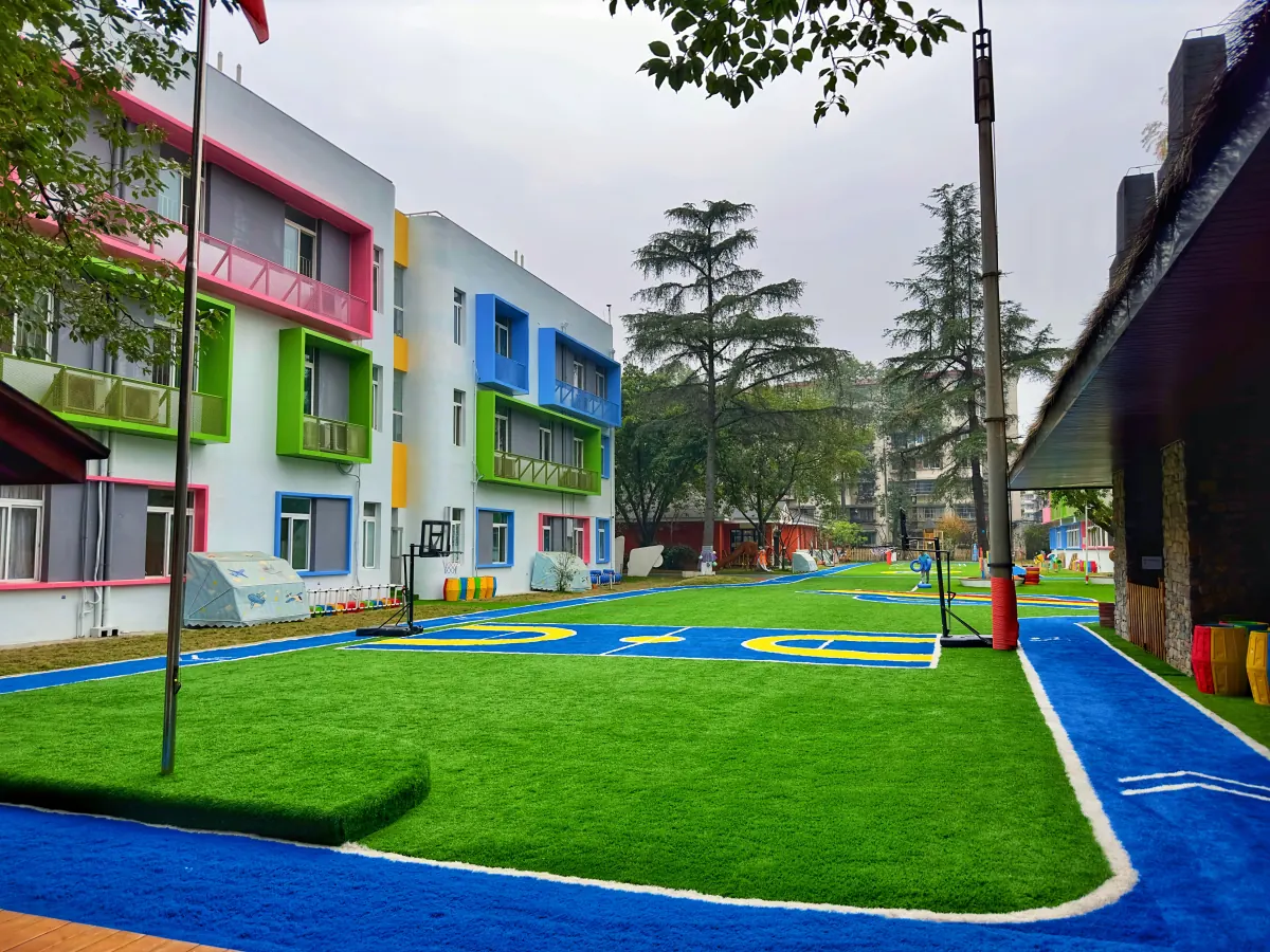 Patio institucional con césped sintético y sectores de juego delimitados